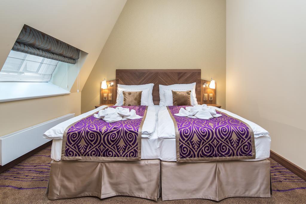Merchants Crown Suites And Spa Praha Bagian luar foto A bed with a bed skirt