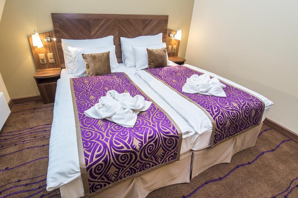 Merchants Crown Suites And Spa Praha Bagian luar foto A bed with a bed skirt